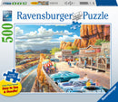 Ravensburger Scenic Overlook 500 pc large format jigsaw puzzle featuring a vibrant scene of a historic roadside with classic cars parked, a restaurant, a general store, and people enjoying the view of the mountains and river in the background. The puzzle emphasizes large piece size for easy handling.