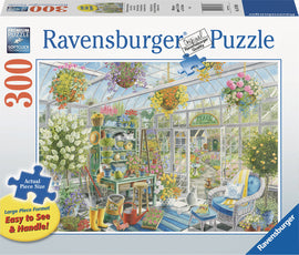 Greenhouse Heaven 300-piece jigsaw puzzle by Ravensburger featuring a vibrant and cozy greenhouse scene filled with flowers, gardening tools, and a cat resting on a chair. The vivid colors and details create a charming visual for puzzle enthusiasts.