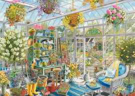 A beautifully detailed jigsaw puzzle titled 'Greenhouse Heaven', featuring a vibrant greenhouse scene filled with colorful flowers, hanging plants, and cozy seating. The image showcases a variety of gardening tools, pots, and a couple of cats lounging among greenery, inviting a sense of peace and tranquility.