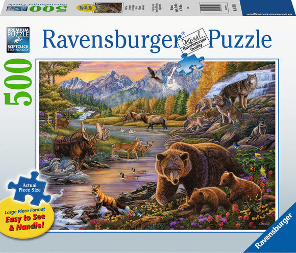 Wilderness 500 pc jigsaw puzzle by Ravensburger featuring a vibrant, detailed illustration of wildlife in a mountainous landscape. The scene includes a variety of animals such as moose, deer, bears, and wolves along a serene river, surrounded by lush trees and colorful flowers. The puzzle is designed in a large format with easily manageable pieces, ideal for both casual and experienced puzzlers.