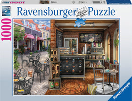 A beautifully illustrated 1000 piece jigsaw puzzle featuring a quaint café scene. The puzzle showcases a charming outdoor seating area with black chairs and tables, a sidewalk lined with greenery, and a cozy café interior adorned with chalkboard menus, coffee machines, and pastries. A playful cat is seen near the tables, adding to the inviting atmosphere.