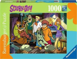 A 1000-piece jigsaw puzzle featuring Scooby-Doo characters in a spooky setting. Shaggy, Scooby, Fred, Velma, and Daphne are seen unmasking a ghost in a dimly lit room, with various mystery-solving tools and eerie decorations around them. The vibrant colors and detailed artwork highlight the fun and adventure of the Scooby-Doo series.