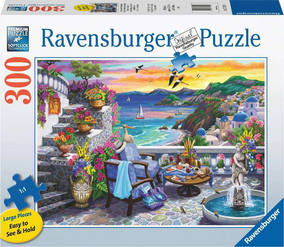 The Santorini Sunset jigsaw puzzle by Ravensburger features a vibrant scene of a coastal terrace adorned with colorful flowers, comfortable chairs, and a table set for leisure. The background showcases a stunning sunset over the sea, with hills, sailing boats, and traditional buildings typical of Santorini, Greece. The puzzle has 300 large pieces that are easy to see and hold, making it perfect for families and puzzle enthusiasts alike.