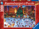 Ravensburger 1000-piece jigsaw puzzle featuring a festive scene at Rockefeller Center during winter. The illustration showcases a busy ice skating rink surrounded by Christmas decorations, a large Christmas tree, and lively skaters in colorful attire, capturing the holiday spirit.