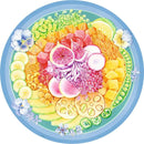 A vibrant 500-piece round jigsaw puzzle featuring a beautifully illustrated poke bowl filled with a variety of colorful fruits and vegetables. The arrangement includes slices of cucumber, bright orange and yellow fruits, purple radishes, and a garnish of edible flowers, all set against a soft blue background. Perfect for puzzle enthusiasts and food lovers alike.