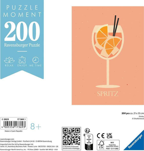 A 200-piece jigsaw puzzle titled 'Puzzle Moments: Drinks' by Ravensburger, featuring a colorful illustration of a spritz cocktail in a glass with orange slices, designed to provide relaxation and enjoyable 'me time'. The box design showcases a light pink background with the word 'SPRITZ' prominently displayed at the bottom.