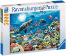 Ravensburger Beneath the Sea 5000 piece jigsaw puzzle box featuring a vibrant underwater scene teeming with colorful fish, coral, and sea turtles, showcasing premium quality and soft click technology for seamless assembly.