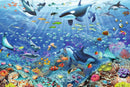 A vibrant jigsaw puzzle depicting a colorful underwater scene filled with various marine life including whales, dolphins, and colorful fish swimming among coral reefs. The artwork features intricate details of sea creatures like stingrays, jellyfish, and tropical fish in a bright blue ocean setting, evoking a lively underwater world.
