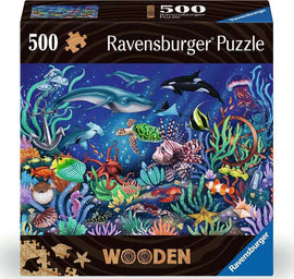 Ravensburger 500-piece jigsaw puzzle titled 'Under the Sea'. The colorful box features an underwater scene with diverse marine life including dolphins, turtles, and vibrant coral reefs, all set against a deep blue ocean background. The packaging highlights the quality and intricacy of the wooden puzzle pieces.