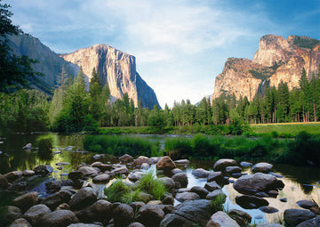 A beautifully detailed jigsaw puzzle depicting Yosemite Valley, featuring stunning rock formations and lush greenery reflected in a calm river. The sunlight bathes the landscape, showcasing nature's beauty in this 1000-piece Ravensburger puzzle.