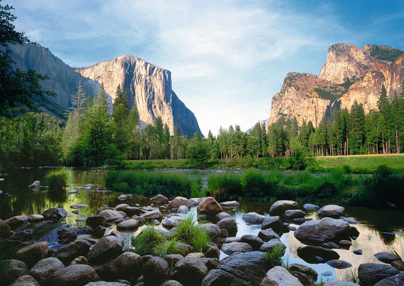 A beautifully detailed jigsaw puzzle depicting Yosemite Valley, featuring stunning rock formations and lush greenery reflected in a calm river. The sunlight bathes the landscape, showcasing nature's beauty in this 1000-piece Ravensburger puzzle.
