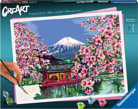 CreArt DIY kit featuring a picturesque painting of Japanese Cherry Blossoms with a serene landscape. Includes pre-printed canvas, vibrant paints, and a paintbrush for creating a stunning artwork of a cherry blossom scene with a mountain in the background.