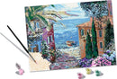 CreArt Mediterranean Landscape DIY kit featuring a picturesque scene with a vibrant coastal view, a pathway lined with flowers, and colorful buildings by the sea. The kit includes paint pots and a brush for creating your own artwork.