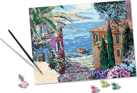 CreArt Mediterranean Landscape DIY kit featuring a picturesque scene with a vibrant coastal view, a pathway lined with flowers, and colorful buildings by the sea. The kit includes paint pots and a brush for creating your own artwork.