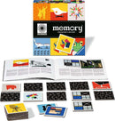Memory Collector's Edition game box by Ravensburger, featuring colorful and artistic images on the packaging. The box is open to reveal game cards and a booklet. The game cards display various designs, including iconic furniture and artistic motifs, arranged neatly on a black surface. The booklet is partially visible with text and images related to the game.