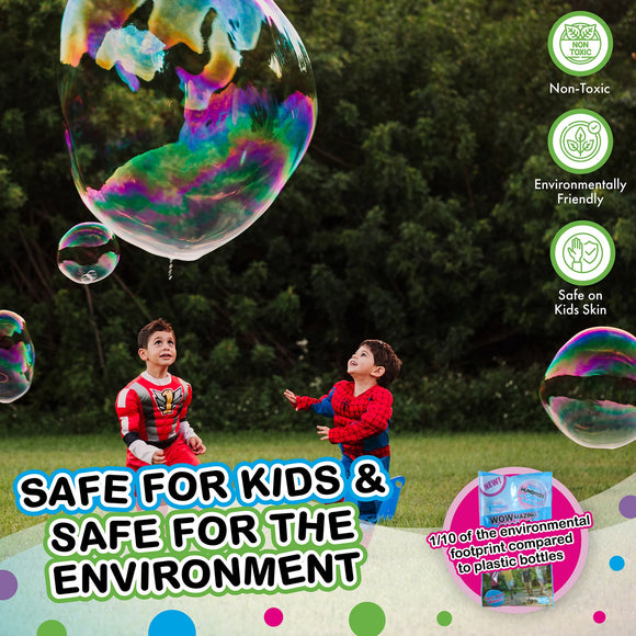 Two young children play outdoors, mesmerized by giant colorful bubbles floating above them. One child wears a superhero costume while the other is dressed as Spider-Man. The scene highlights the joy of bubble play, emphasizing the product's non-toxic and environmentally friendly features that are safe for kids' skin.
