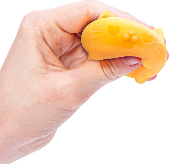 A person holds the Teenie Cool Cat Nee Doh fidget toy, which is shaped like a cute yellow cat. The toy features heart-shaped accents on its face, providing a fun and squeezable experience.