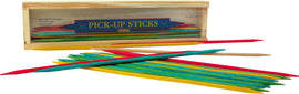 Colorful pick-up sticks scattered around a wooden box labeled 'PICK-UP STICKS' by Schylling. The game features various colored sticks including red, yellow, green, and a natural wooden stick, ideal for family fun and coordination skills.