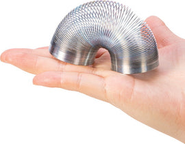 A hand holding a Mini Sproing, a colorful metallic toy shaped like a spiral slinky. The toy is designed to stretch and bounce, providing tactile fun and entertainment.