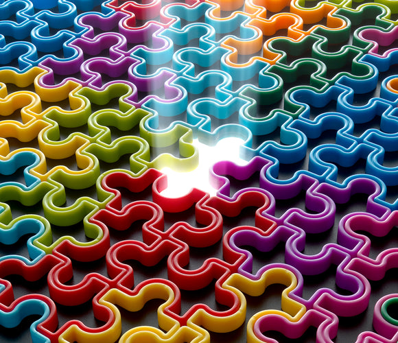 The IQ Jigsaw from Smart Toys & Games features a vibrant arrangement of interlocking mechanical jigsaw puzzle pieces in various colors, including blue, yellow, green, red, purple, and orange. The pieces display unique shapes, showcasing their mechanical design, with a few pieces not yet placed, highlighting the challenge of the puzzle. The background is a simple contrast to make the colorful pieces stand out.