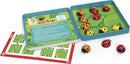 LogiBugs mechanical puzzle by Smart Toys & Games, featuring colorful ladybug pieces in a grid layout. The image shows a sliding puzzle game container with ladybug tokens. An instruction booklet is partially visible, indicating various challenge levels, including expert options. This engaging game promotes problem-solving skills for children and adults.
