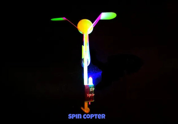 The Spin Copter: LED Slingshot Helicopter features a colorful, illuminated design with vibrant spinning blades and a glowing base. Perfect for outdoor fun and night-time play.