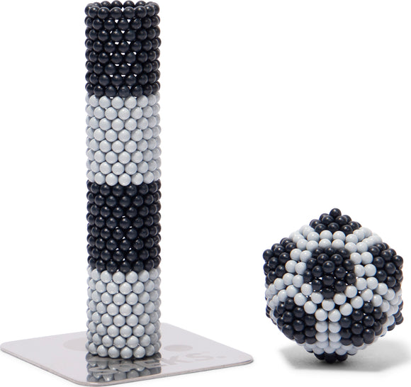 Speks Elements: Lunar features a dimensional structure made of magnetic beads in alternating black and white patterns, accompanied by a spherical shape crafted from the same material. Ideal for stress relief and tactile enjoyment.