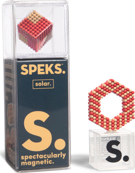 The Speks Elements: Solar features a vibrant magnetic building set, showcasing a cube and a hexagonal structure made of colorful magnetic spheres. The packaging is clear, with bold graphics highlighting the extraordinary qualities of the product.