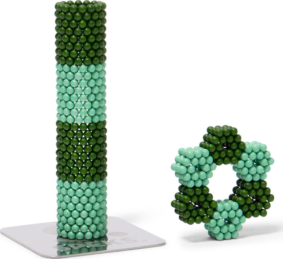 Speks Elements: Terra by SPEKS, featuring a tall structure made of green and teal magnetic balls, next to a smaller star-shaped design. Both are displayed on a shiny base that enhances their vibrant colors. Ideal for stress relief and creative play.