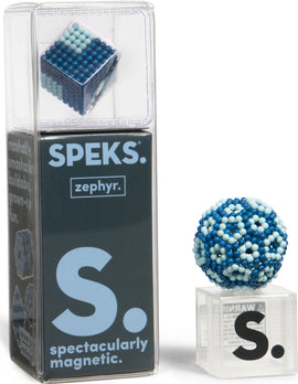 SPEKS Elements: Zephyr is a magnetic toy set featuring a cube and a sphere made of colorful magnetic beads. The packaging displays the product name and highlights its playfulness and stress-relieving qualities, making it a unique fidget and hands-on experience for adults and children alike.