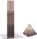 The Speks Reflect Gradient features a collection of shiny metal balls, designed for creative building. This set includes structures such as a tall cylindrical tower and a smaller pyramid shape formed from magnetic beads. Ideal for stress relief and enhancing focus, it combines fun and functionality.