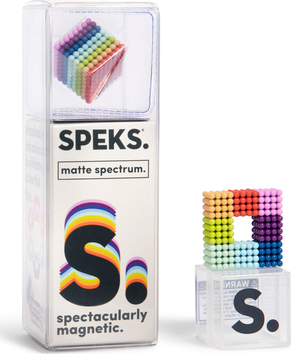 Speks Matte Spectrum fidget toy featuring a colorful arrangement of small magnetic spheres, displayed in a clear packaging. The product is designed for creative building and stress relief, with vibrant colors that include purple, blue, green, yellow, orange, and red. It showcases a unique square formation of spheres, enhancing visual appeal and inviting hands-on interaction.