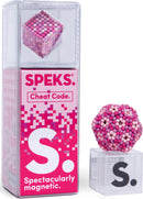 The Speks Pixel Cheat Code is a uniquely designed magnetic fidget toy presented in a clear plastic package. It features a vibrant assortment of pink and purple magnetic spheres arranged in various geometric shapes, including a cube and a larger spherical formation. The packaging displays bold branding from SPEKS, emphasizing the product's imaginative and playful nature, perfect for relieving stress and stimulating creativity.