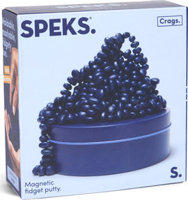 The SPEKS Crags Matte: Indigo is a container of magnetic fidget putty in a deep indigo color. The putty is showcased spilling out of its round container, resembling a playful mound overflowing with smooth, oval-shaped pieces. The packaging emphasizes the qualities of being moldable, mashable, and fun, appealing to those seeking stress relief or sensory play.
