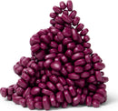 A pile of small, glossy, purple-edged beads resembling jelly beans, showcasing a variety of shapes and sizes. Ideal for creative DIY projects or sensory play.