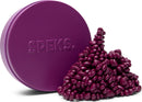 A round purple tin labeled 'SPEKS.' sits alongside a pile of small, glossy, purple beads that resemble pebbles. The arrangement showcases the vibrant color and unique shape of the beads, which are perfect for fidgeting and creative play.