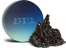 A colorful tin container labeled SPEKS, featuring a mound of flexible and malleable black magnetic pieces spilling out. The container has a gradient design transitioning from blue to silver, showcasing the brand's logo prominently. This item is perfect for stress relief and creative play.