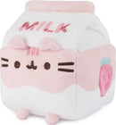 A cute Pusheen plush toy designed to look like a strawberry milk carton. The plush features soft pastel colors, with pink and white fur, embroidered details, and a strawberry graphic. It has a friendly face with whiskers and rounded ears, making it an adorable addition to any plush collection.