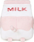 A plush toy shaped like a strawberry milk carton featuring the word 'MILK' in pink embroidery. The toy has a pink and white color scheme with a cute tail and small feet, perfect for cuddling and décor.