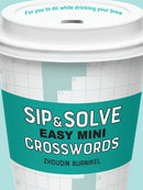 Close-up of a coffee cup featuring the title 'Sip & Solve Easy Mini Crosswords' by Zhouqin Burnikel. The cup is decorated with crossword grids and a stylish turquoise design, indicating it's a fun activity to enjoy while sipping your favorite beverage.