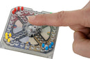 World's Smallest Trouble game by Super Impulse, featuring a colorful board with pegs and dice. A finger is seen pressing down on the transparent dome, indicating gameplay.