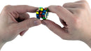 A person holds the World's Smallest Rubik's Cube made by Super Impulse between two fingers, showcasing its compact size. The cube features colorful squares in a traditional Rubik's Cube pattern, illustrating the intricate design of this mechanical puzzle.