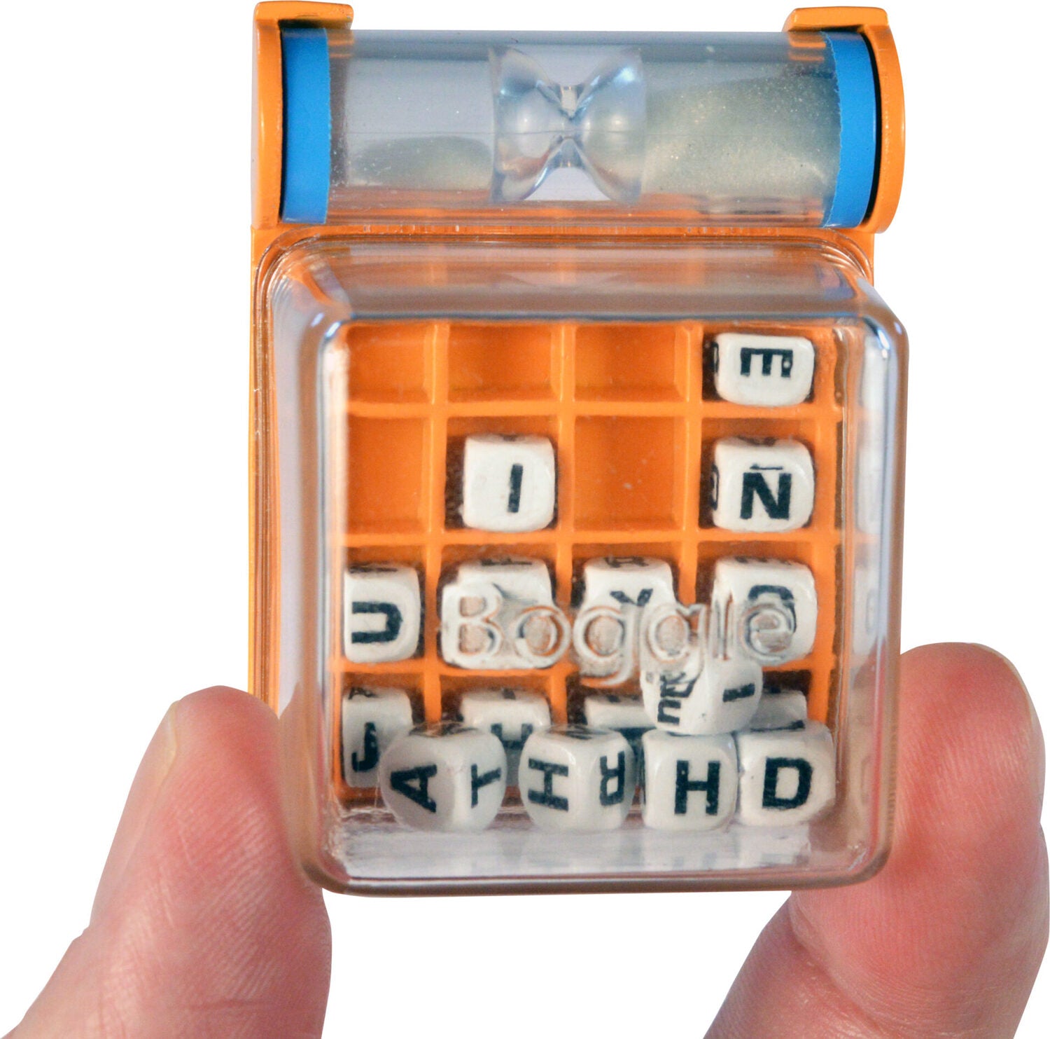 A person holding the World's Smallest Boggle game by Super Impulse. The game features a transparent cube with an orange base containing lettered dice inside, ready for word-finding fun. An hourglass timer is visible on the top, indicating it's a fast-paced game.