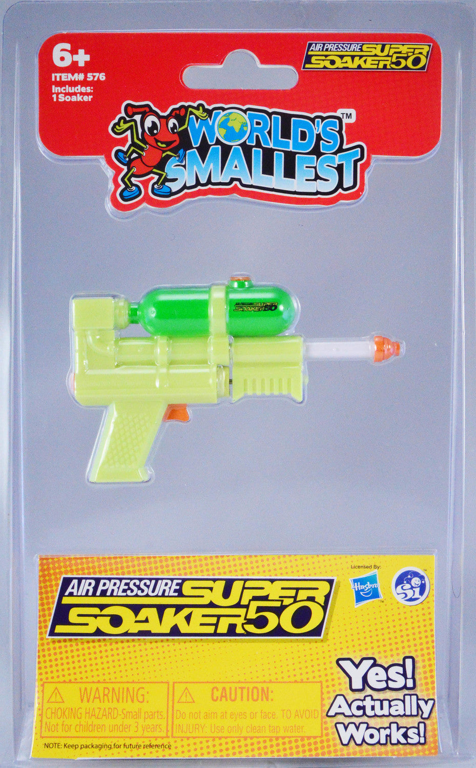 The World's Smallest Super Soaker displayed in its packaging. The tiny toy water gun features a vibrant green and yellow design, with a clear chamber showing a small water reservoir. Ideal for kids aged 6 and above, it boasts air pressure functionality and claims to actually work, making it a fun addition to summer play. The packaging includes safety warnings and notes on usage.