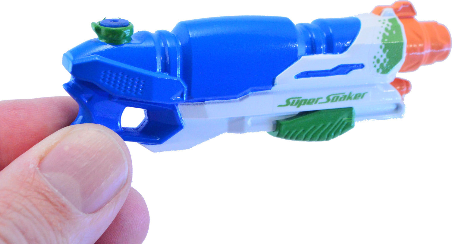 A person holding the World's Smallest Super Soaker by Super Impulse. The mini water gun features a blue body with green and orange accents, designed for fun and play.