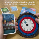 A close-up of the game 'Exit: The Hunt Through Amsterdam' by Thames & Kosmos. An individual holds a card featuring a silhouette of two people walking by a canal, with a Dutch-style building in the background. Next to it, a circular game piece with red and blue segments and numbered sections is displayed, showcasing the puzzle-solving mechanics for friends and families.