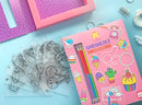 Tiger Tribe's Sweat Treats Shrinkies DIY kit, featuring colorful pencils, outlined plastic sheets with fun food-themed designs, and crafting supplies. Ideal for creative kids to design and make custom charms and accessories.