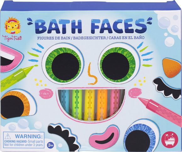 The packaging for Bath Faces by Tiger Tribe features colorful and whimsical face parts including large googly eyes, a smile, and various features like noses and eyebrows, along with brightly colored markers for customization. It's designed for fun in the bath, appealing to children with its cheerful design.
