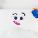 A playful assortment of foam facial features arranged on a white bathtub surface, featuring large blue eyes, a pink tongue, and eyebrow pieces scattered around. Bubbles can be seen below, creating a fun and inviting bath atmosphere.