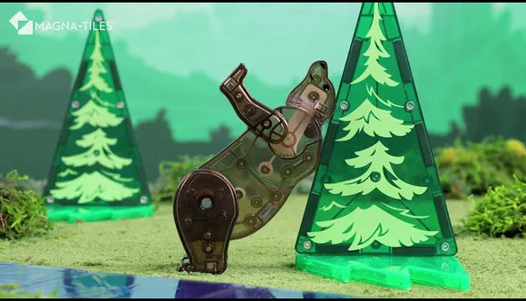 A playful scene showcasing a Forest Animals DIY kit by Magna Tiles. The kit features a transparent green tree and a moving animal figure resembling a bear interacting with the tree. The vibrant colors and engaging design encourage imaginative play and creativity.